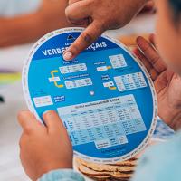 Child looking up a verb conjugation with the French Verbs Wheel